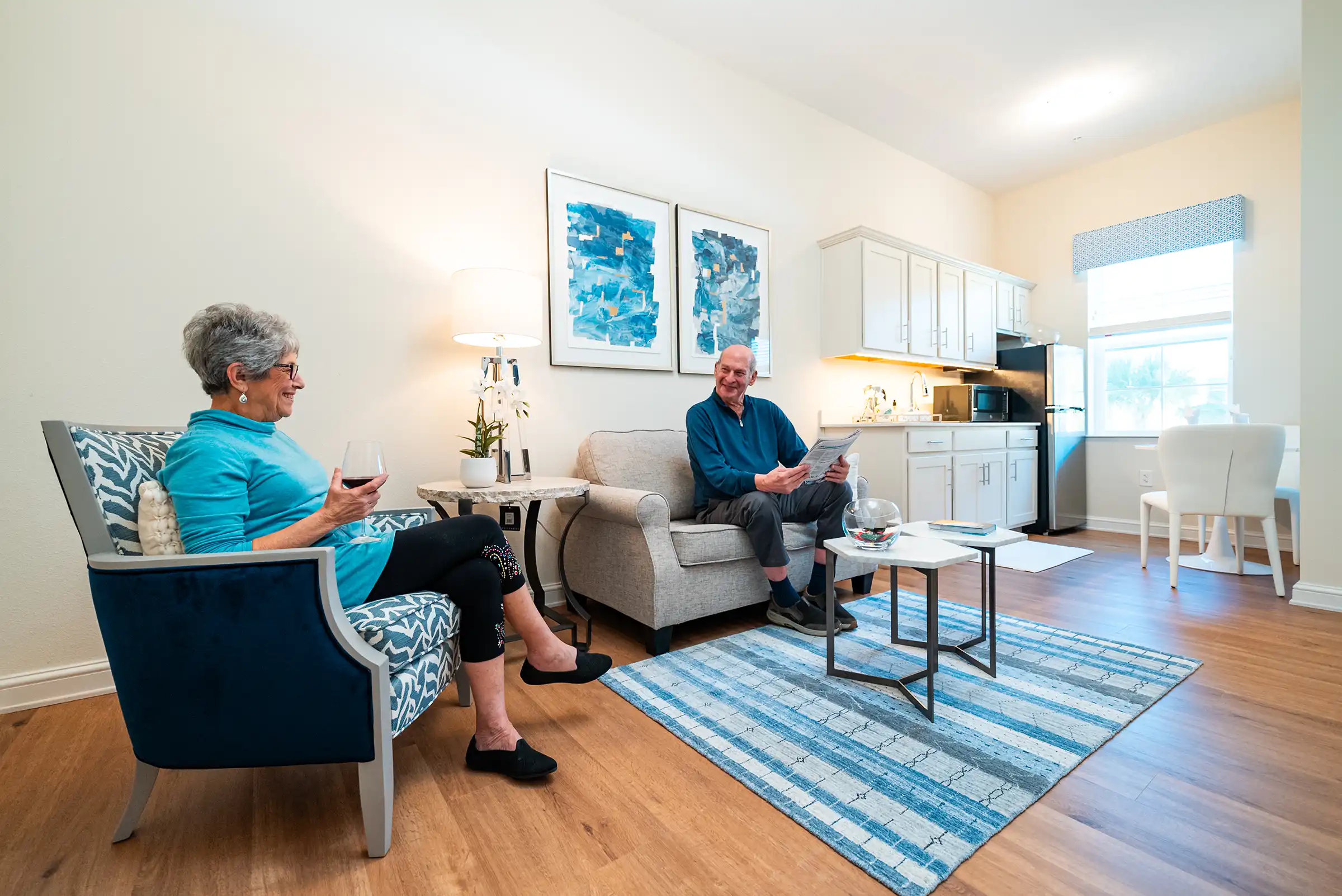 A senior couple sit together in a modern-style appointed living area