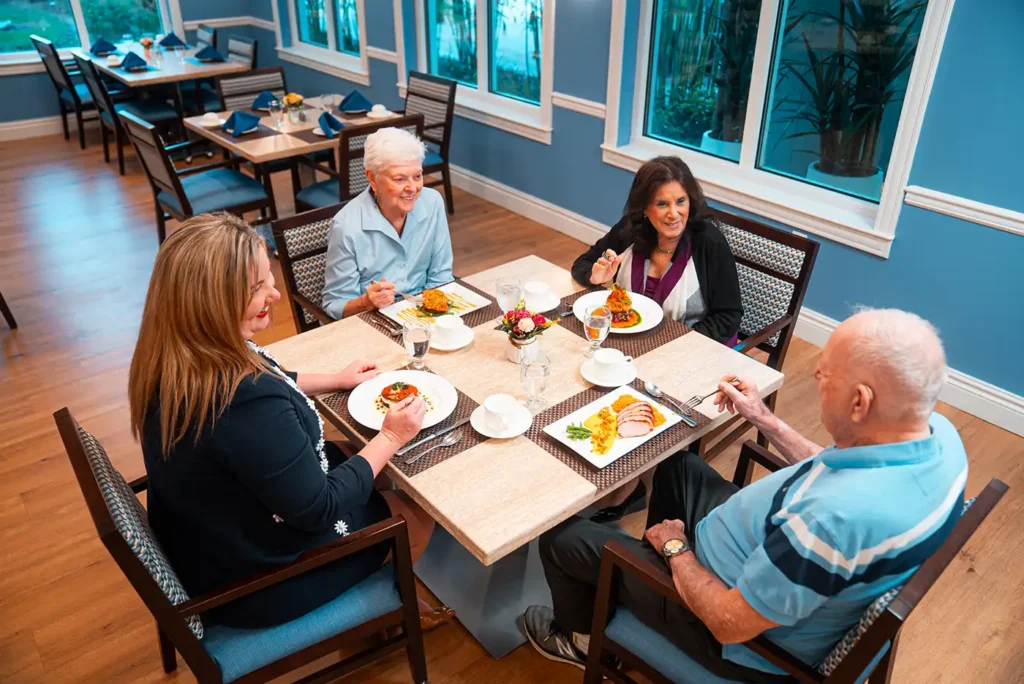 A group of senior adults sit and have a meal around a dinner table