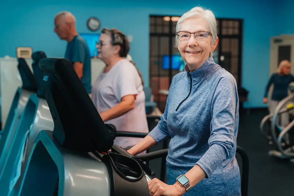 A senior woman walks on a treadmill in a fitness center