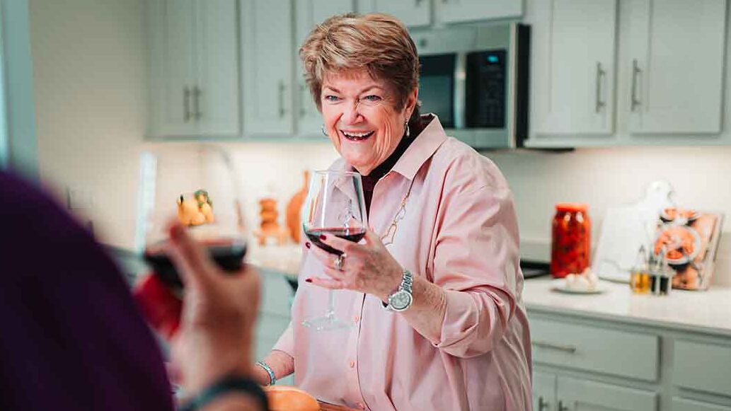 A woman entertains in her kitchen with wine and charcuterie 