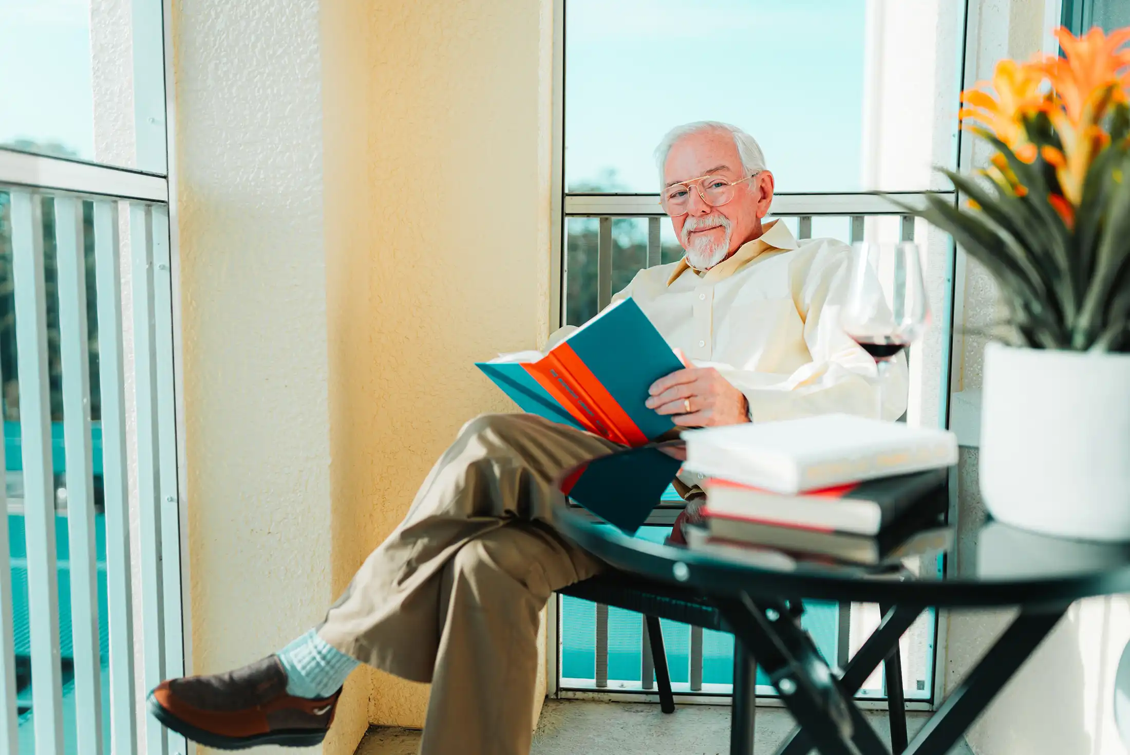 A senior man reads in a patio